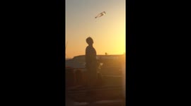 Barman juggling bottles at sunset