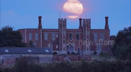 Sturgeon Full Moon moon seen rising above historic gatehouse in Kent, UK