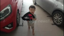 Adorable diligent toddler helps mum to collect dried washed clothes