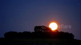 Full 'Sturgeon Moon' rising over Peak District National Park in central England