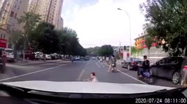 Girl falls from moving scooter in front of car on busy road in China