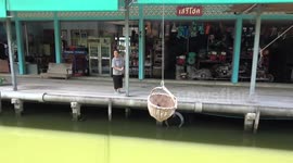 Shopkeepers use quaint 'flying baskets' to serve customers on canal in Thailand