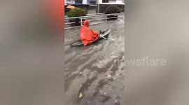Chinese man rows across flooded streets to get to work
