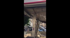 Girl cleanig a gas station that has been shattered because of the explosion
