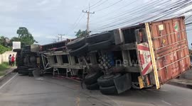Container truck falls on two cars but families miraculously survive