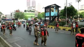 Police in Jakarta stop motorcyclists not wearing masks