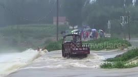 Firefighters use excavator to rescue three-wheeler driver trapped on flooded bridge