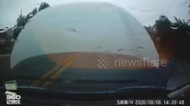 Hood flies off car driving along Chinese road