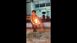 Vietnamese street performer eats burning charcoal in fiery display