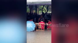 Chinese women calmly play mahjong while sitting in deep floodwater