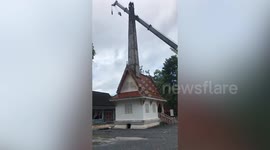 Bungling crane operator knocks over 50ft high chimney and crushes sacred Buddhist crematorium