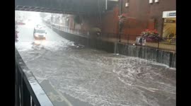 Cars drive straight through flooded bridge in Greater London
