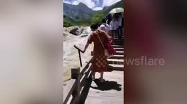 Woman deliberately pushes over warning boards and bins at Chinese scenic spot