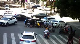 Passersby lift car up together to free biker trapped under the vehicle in China