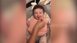 Cute moment baby daughter tries solid food for the first time