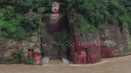 Flash floods submerge feet of famed giant Buddha statue after heavy rain