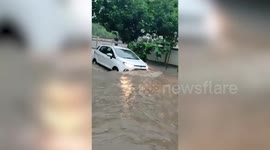 Residents wade through flooded roads in Delhi, India