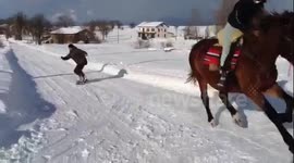 Snowboarder towed by horse