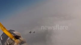 Wingsuit flyer passes skydiver at amazing speed