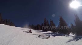 Snowboarder wipes out skiing friend