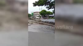 River overflows onto road after heavy rain in the Philippines