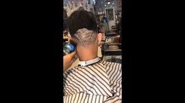 Vietnamese barber shaves rose into man's hair