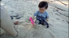 Angry moment of a toddler when asking for stop playing sand on beach
