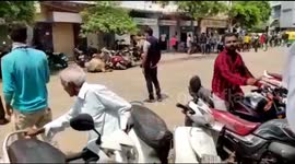 Two women knocked off their scooter by raging bull in west India