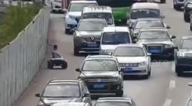 Chinese boy driving toy car on busy highway breaks down