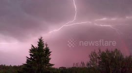 Lightning strikes under red rainbow in western Canada