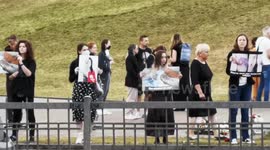 Women hold pictures of injuries sustained by protesters during rally in Minsk