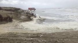 Storm Francis blows sea foam on beach in Netherlands