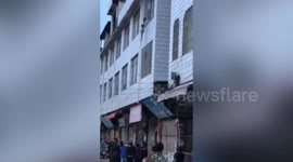 Chinese crowd hold bedsheet to catch 5-year-old thrown out of burning flat by mother