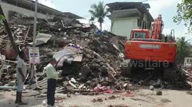 Four-storey building collapses in western India leaving debris scattered across road