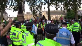 Lie-in Extinction Rebellion protesters watched by police officers at Parliament Square demo