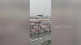 Powerful winds brought by Typhoon Maysak rip off building roof and blow over trees