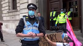 Carnival of Corruption rebel with Oil Money is Blood Money placard outside HMRC building in Westminster