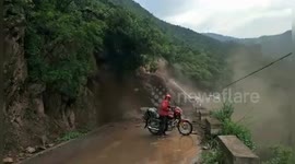 Chinese motorcyclist calmly watches massive landslide  in front of him