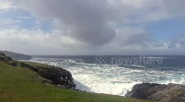 Watch as sea foam swirls up and over the cliffs in the Shetlands