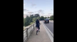 Beautiful girl with curly hair riding bike in London