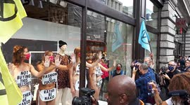 Near-naked Extinction Rebellion protesters glue themselves to H&M Oxford Street window