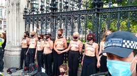 Topless Extinction Rebellion protesters lock themselves to London's parliament gate
