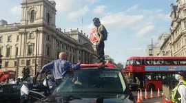 Climate change activist protests on car roof in Parliament Square during the final day of Extinction Rebellion demonstrations.