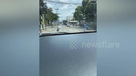 Kind motorist carries elderly disabled woman across the road in Thailand