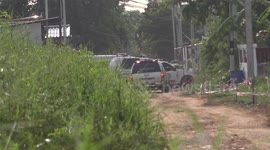Emergency service vehicles and an ambulance, have difficulty travelling a dirt track to the scene of an emergency in rural Thailand.
