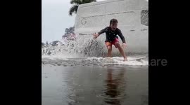 Father-son duo create waves to surf on flooded Florida street