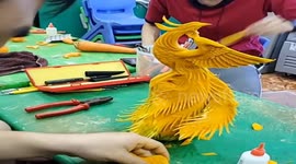 Vietnamese man sculpting fire phoenix from pumpkins