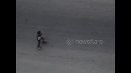 child plays with ski boot in an empty street in Gaza