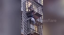 Chinese man holds up 4-year-old boy dangling from window before firefighters arrive