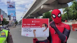 Police and Superheroes Distribute Masks on the Street of Makassar City